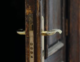 gold door lever on brown wooden door