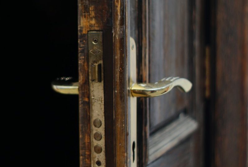 gold door lever on brown wooden door