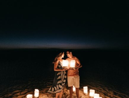 man and woman standing outdoors holding paper lanterns