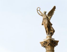 angel holding round wreath statue]