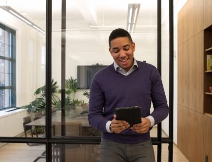 a man standing in an office looking at a tablet