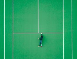 aerial photography of person lying on tennis court