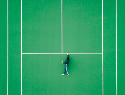 aerial photography of person lying on tennis court