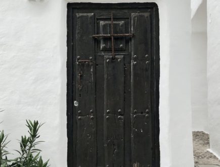 white building with closed black wooden door